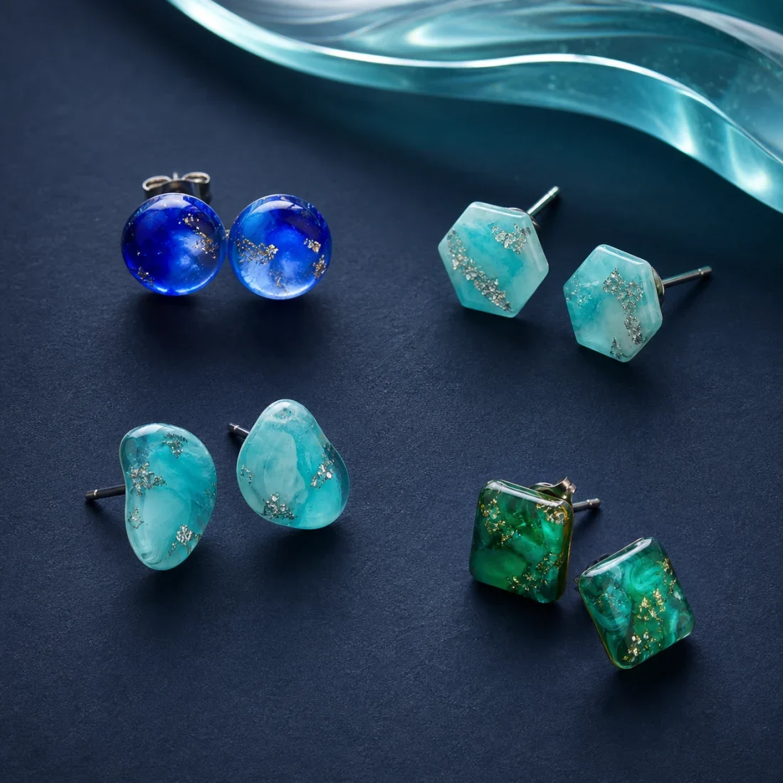 Vier Paare glänzende Ohrstecker aus blauem, türkisem und grünem Epoxidharz